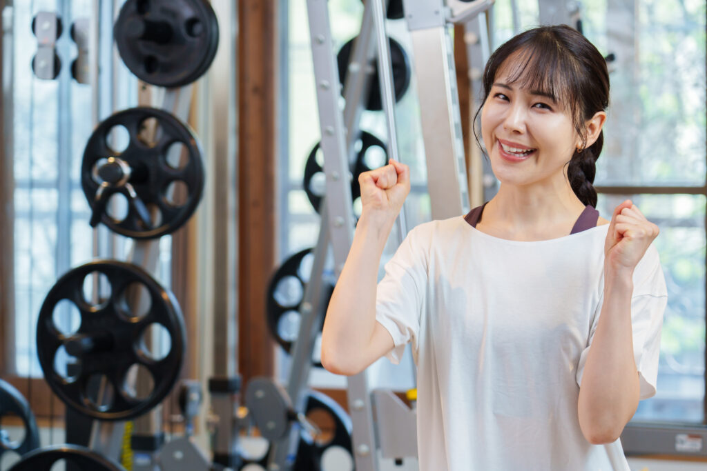 スポーツジムでガッツポーズをする女性