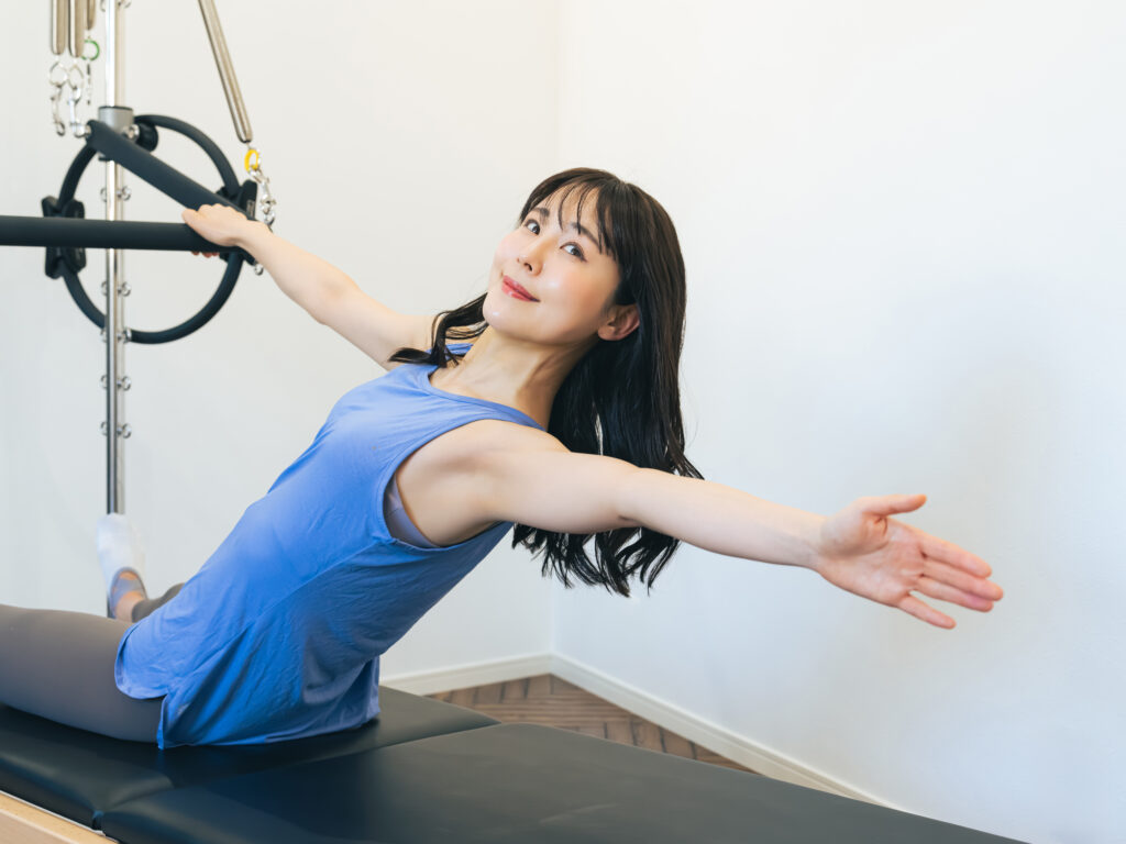 マシンピラティスで運動を行う女性