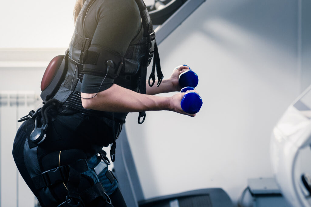 EMSスーツを着てダンベルで運動する女性のクローズアップ写真