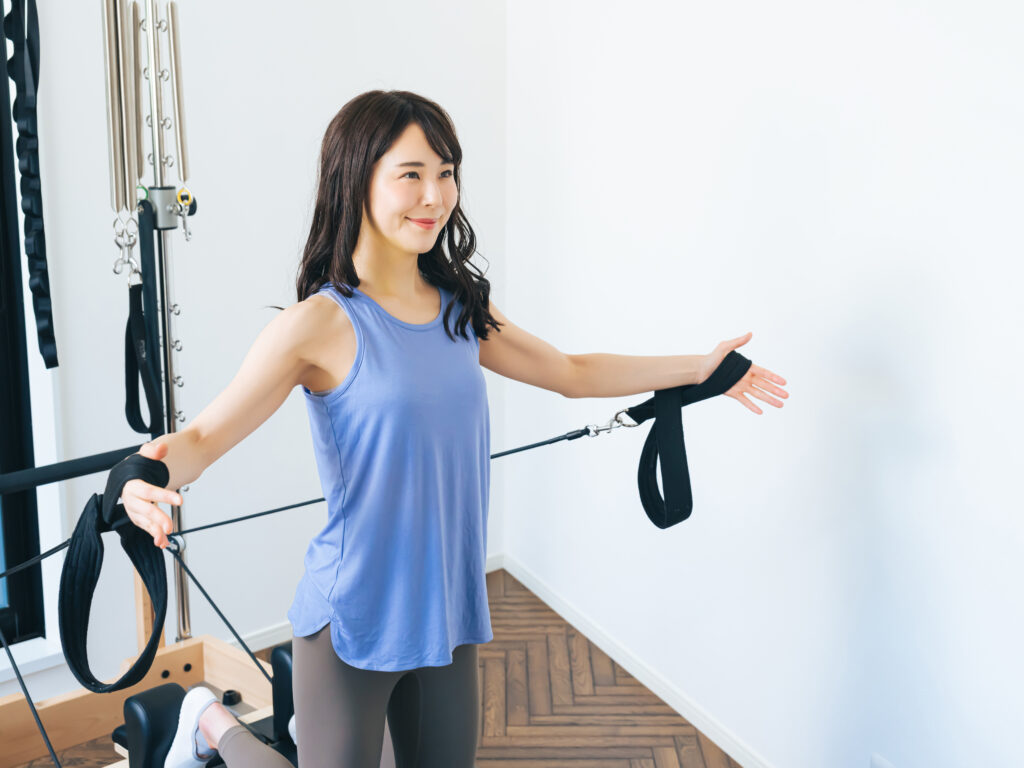 マシンピラティスのトレーニングをする人