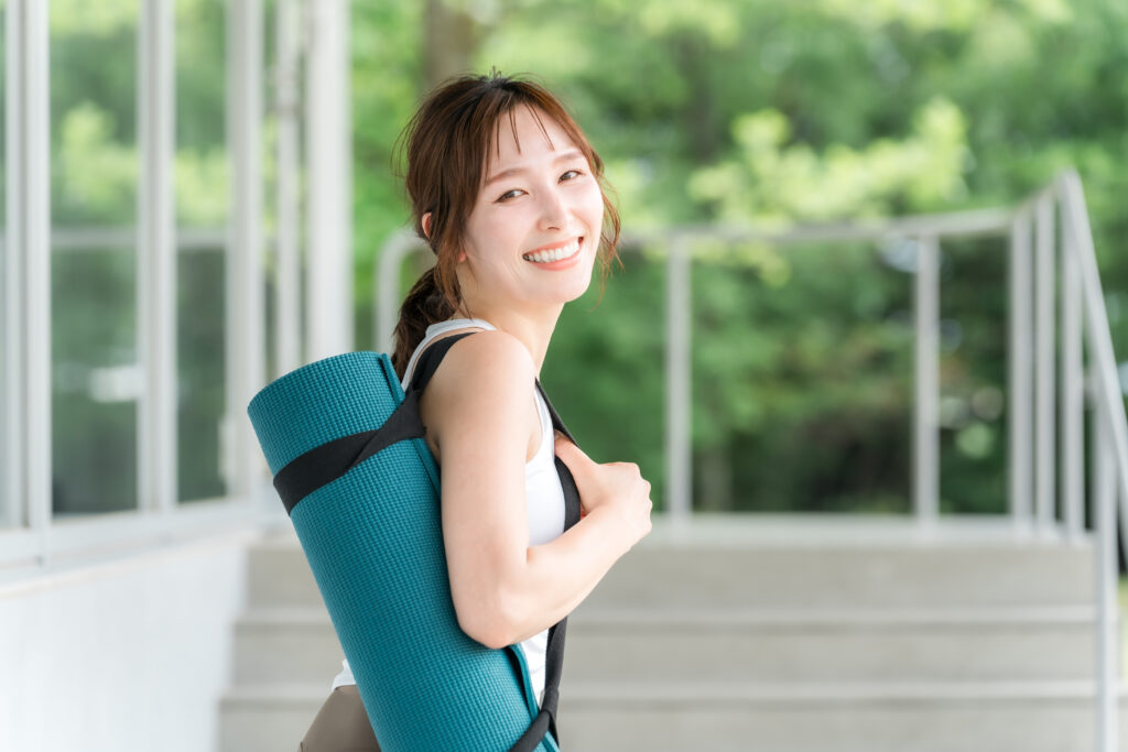 ヨガマットを持った健康的な女性