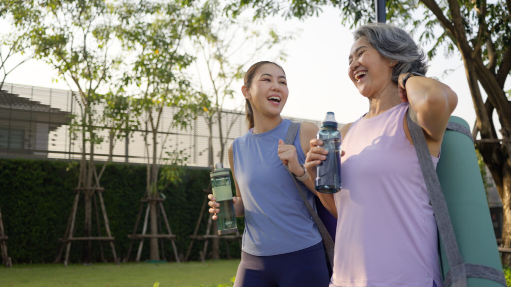 若い女性とお母さんが、ヨガマットとウォーターボトルを持ってピラティスに向かう画像