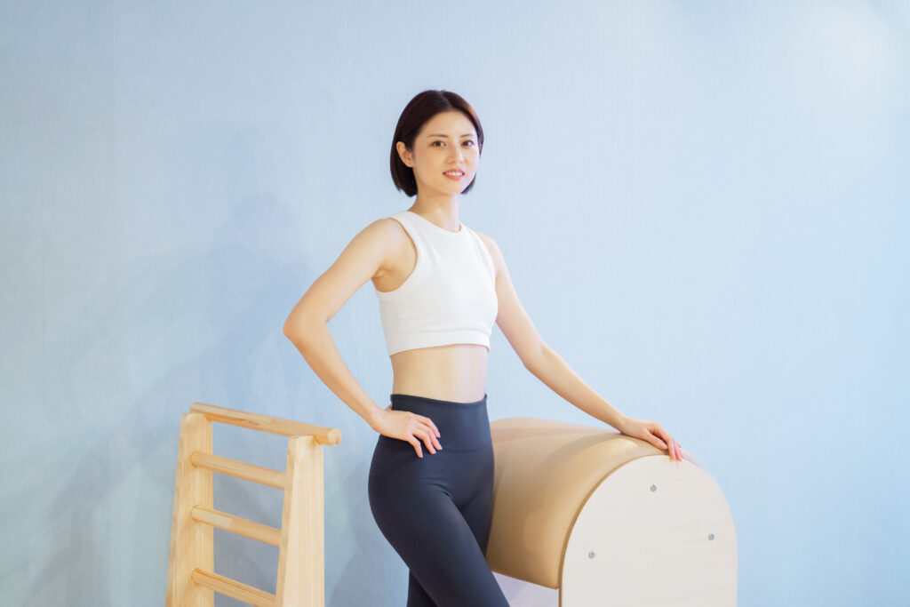 ピラティスインストラクター-日本人女性がラダーバレルでポーズ