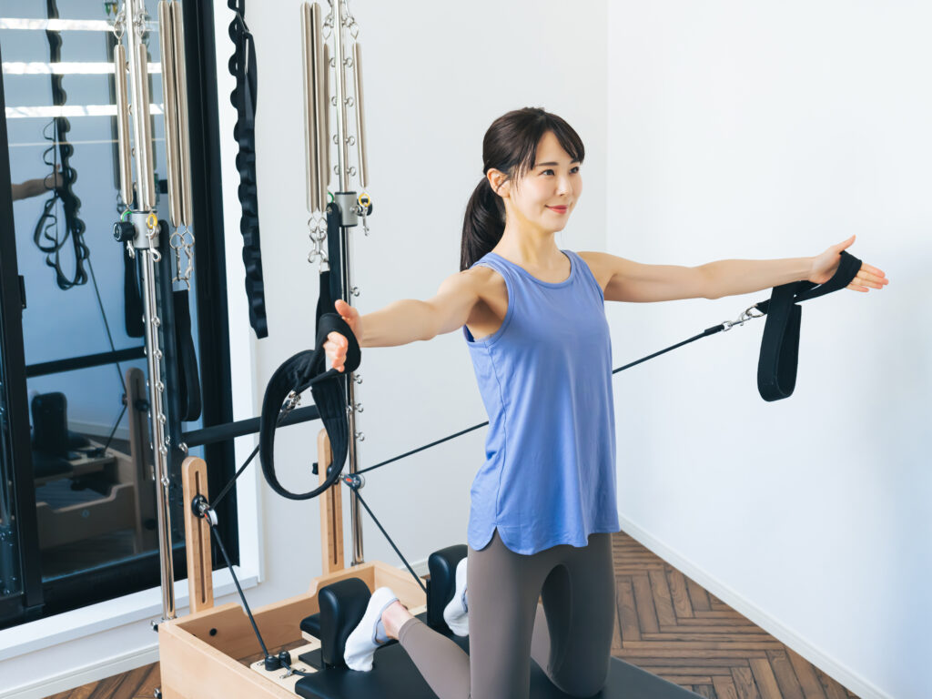 マシンピラティスのトレーニングをする女性