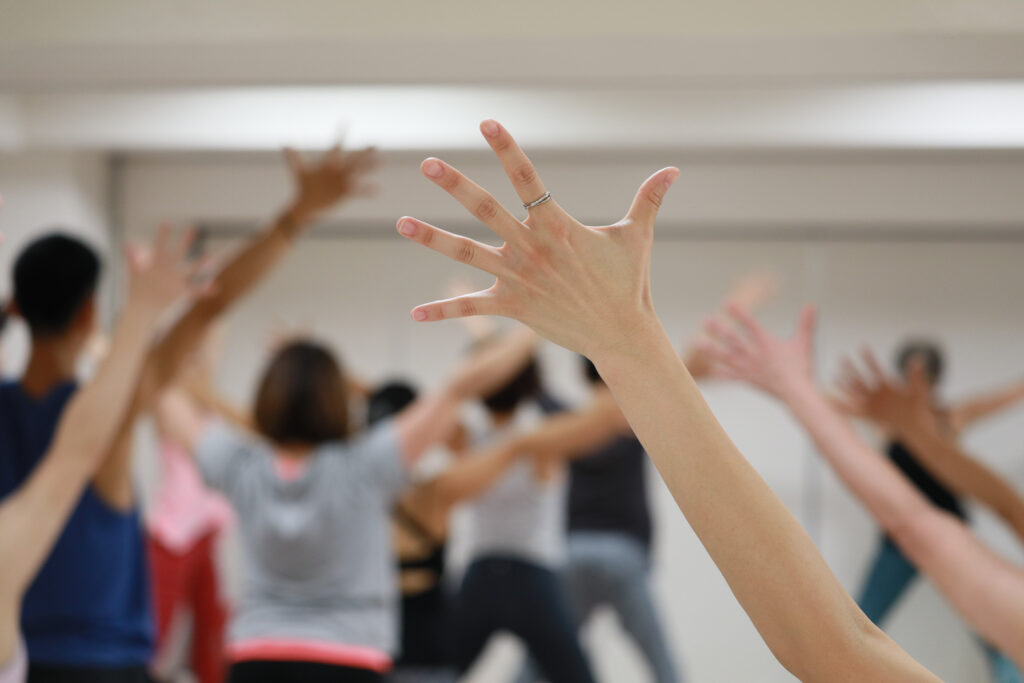 スタジオでグループレッスンを行う女性の手