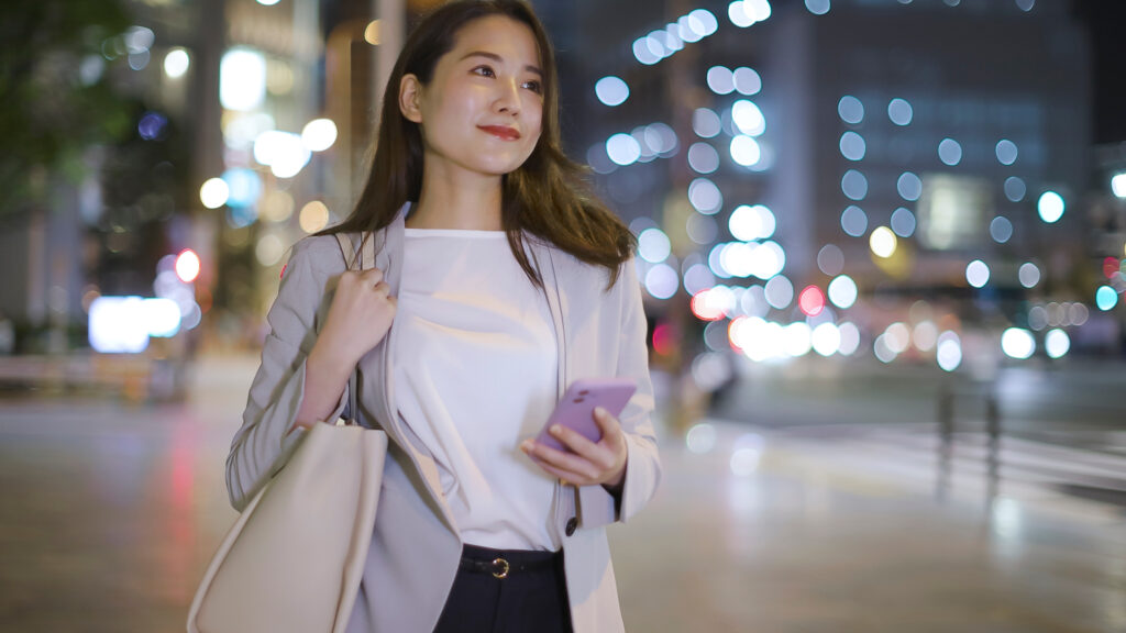 会社帰りにスマホを見るビジネスウーマン