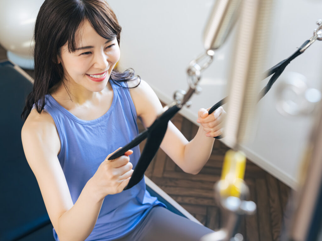 マシンピラティスのトレーニングをする女性