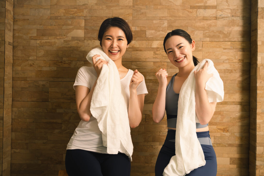 汗をタオルで拭う2人の若い女性