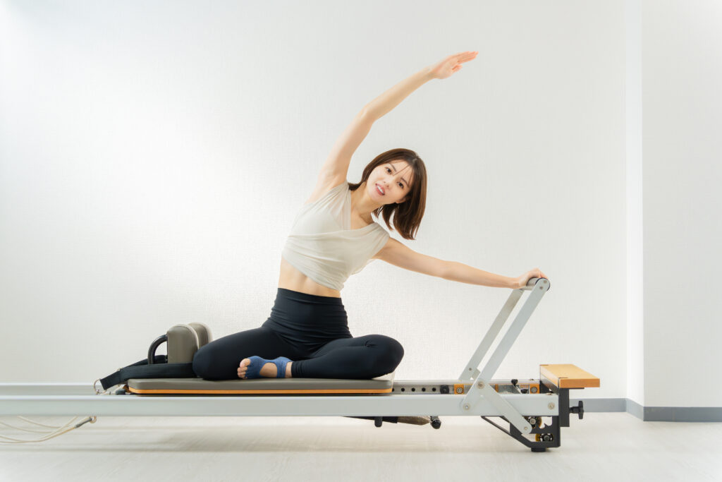 ピラティス女子 日本人女性がリフォーマーでポーズ