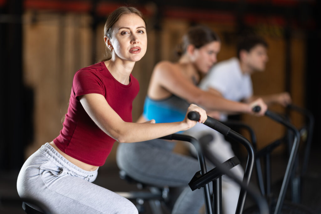 ジムのバイクで有酸素運動をする女性