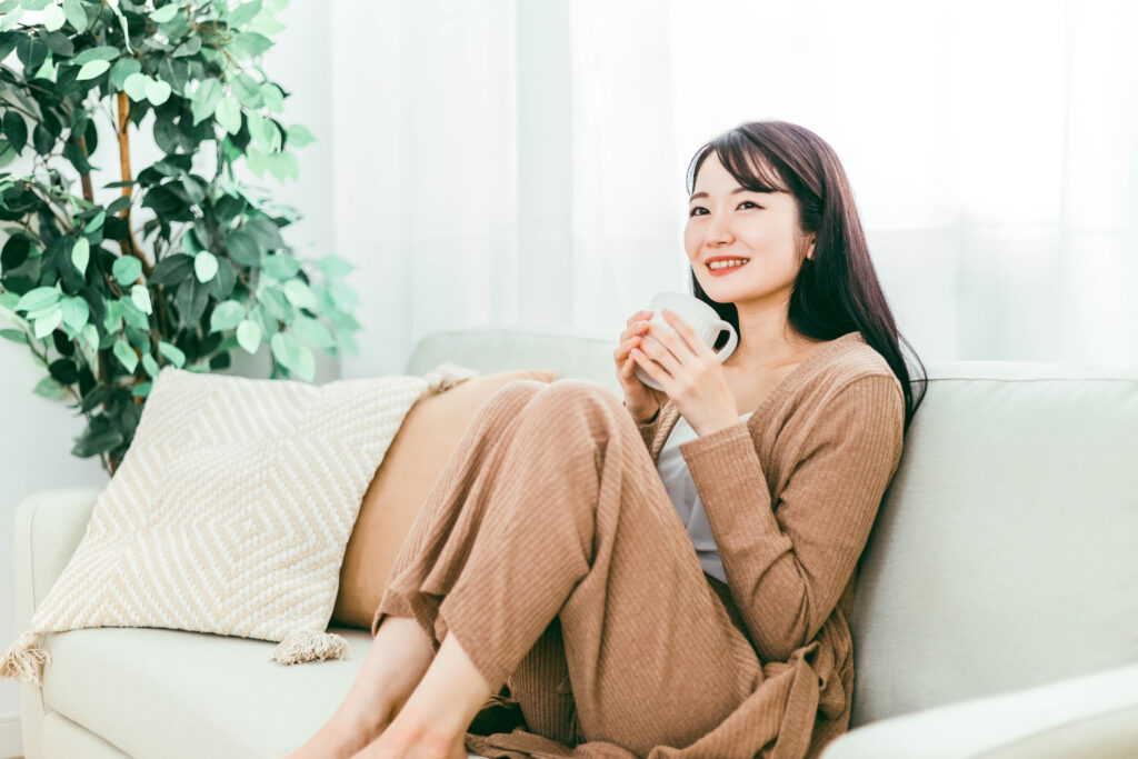 温かい飲み物を飲んで体を温めている女性