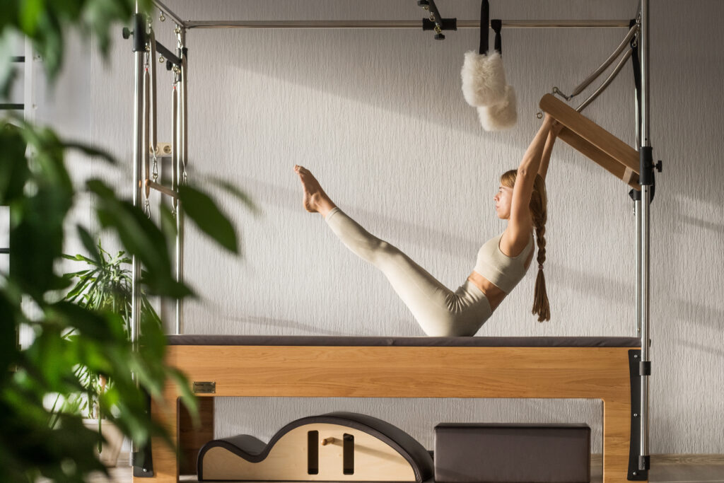 ピラティススタジオでエクササイズを行うトレーナー